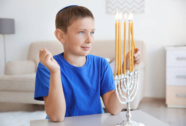 Jewish boy lightning menorah at home - Fotoğraf, Görsel