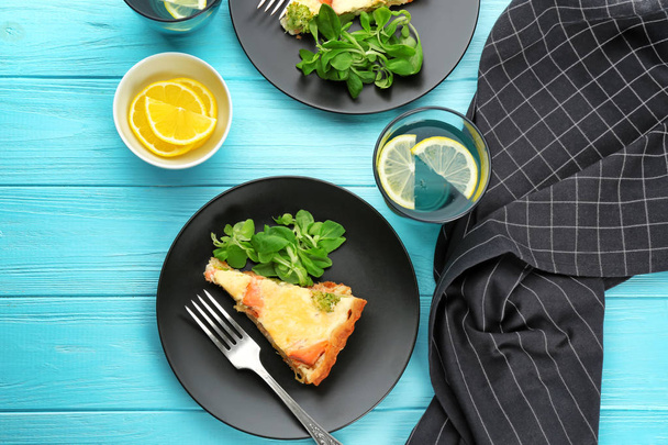 Plate with piece of salmon quiche pie on table - Fotoğraf, Görsel