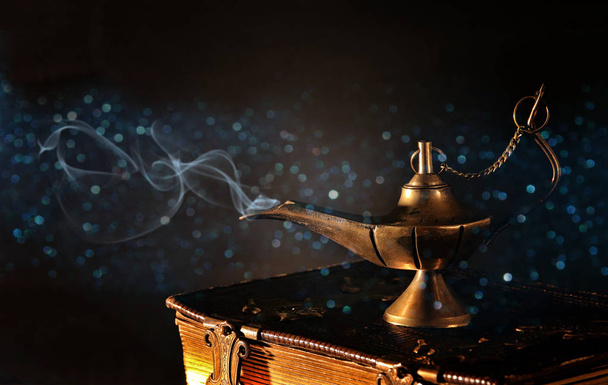 Image of magical aladdin lamp with gold glitter smoke. Lamp of wishes - Photo, image