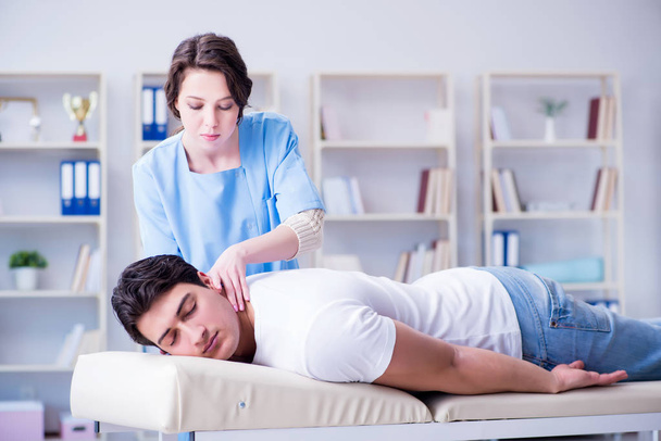 Female chiropractor doctor massaging male patient - 写真・画像