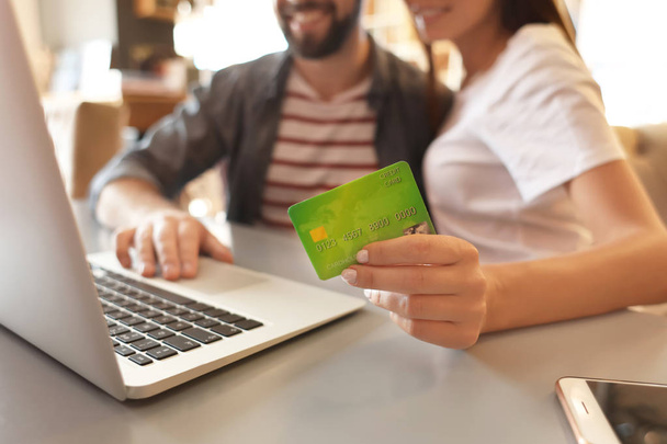 Couple with laptop and credit card indoors. Internet shopping concept - Foto, imagen