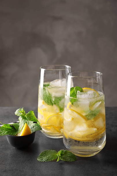 Glasses of cocktail with mint and lemon on grey background - 写真・画像