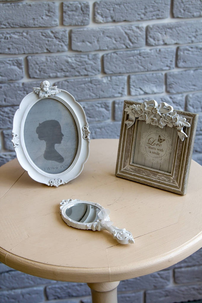 alte Bilderrahmen, liegender Spiegel auf dem Tisch mit grauem Backsteinhintergrund Fernsicht - Foto, Bild