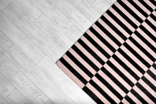 Black and white striped carpet on floor - Фото, зображення