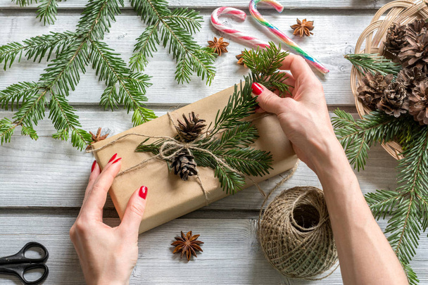 Woman hands decorating gift box in Christmas style. View from ab - Photo, image