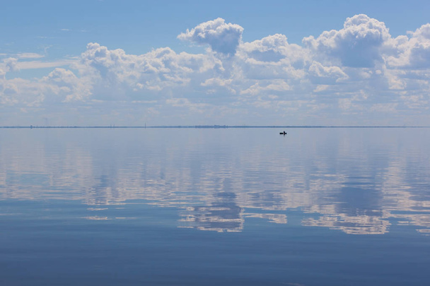 Deep blue surface of a calm sea merging with the clouded sky. Th - Fotoğraf, Görsel