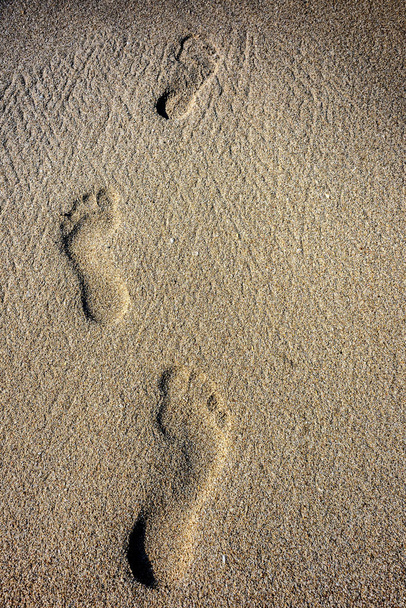 Emberi lábnyomok a homokban - Fotó, kép