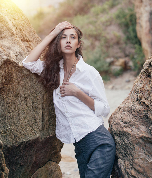 business woman on suit and white shirt standing near big stone on the sea cost - Photo, image