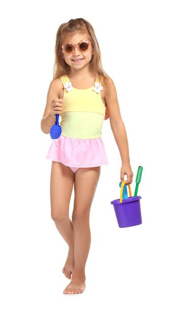Adorable little girl in swimsuit with plastic toys on white background - Fotó, kép