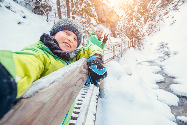 Boy take a selfie picture with his father in snow mountain canyo - Photo, Image