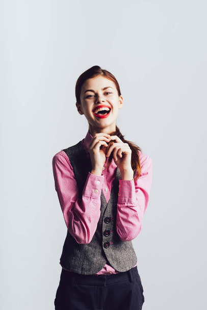 young beautiful girl with red lips and in a gray office vest laughs - Photo, Image