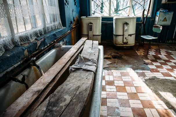 Hylätty pesula, vanhat pesukoneet, ruosteinen kylpyammeet
 - Valokuva, kuva