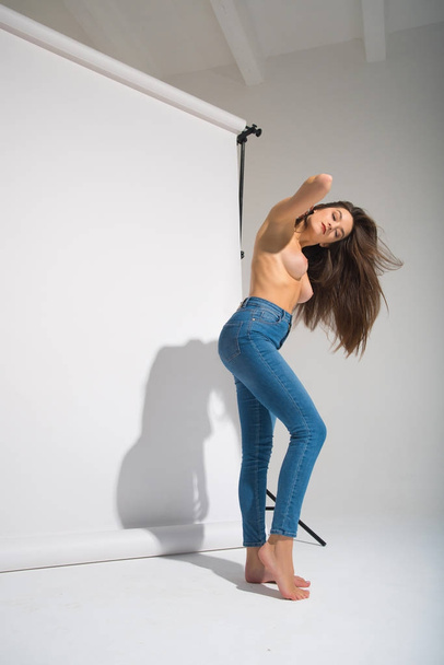 Beautiful Naked Woman In Blue Denim Jeans And White Underwear Posing Casting Shadow Isolated On The Gray Background - Foto, Imagem