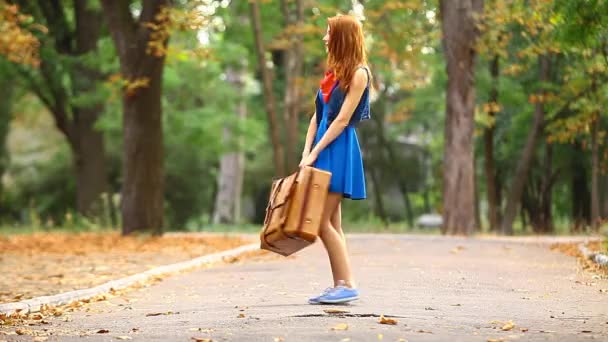 Žena v modrých šatech s kufrem - Záběry, video
