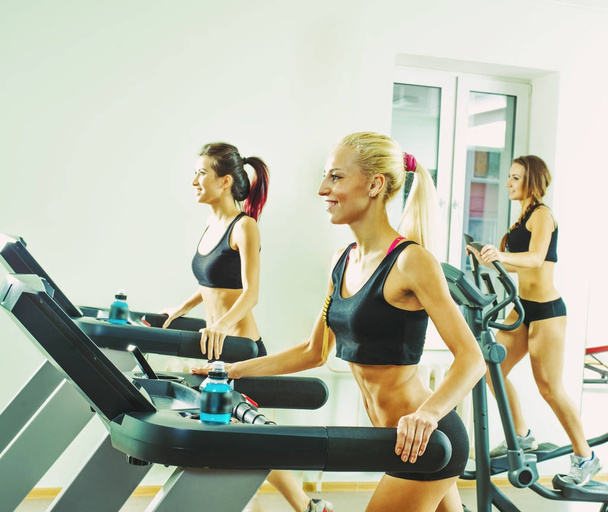  young sporty women running  on treadmills  in the gym - Foto, Bild