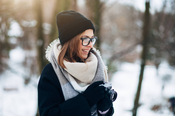 Κορίτσι στο πάρκο χειμώνα με φωτογραφική μηχανή ταινία - Φωτογραφία, εικόνα
