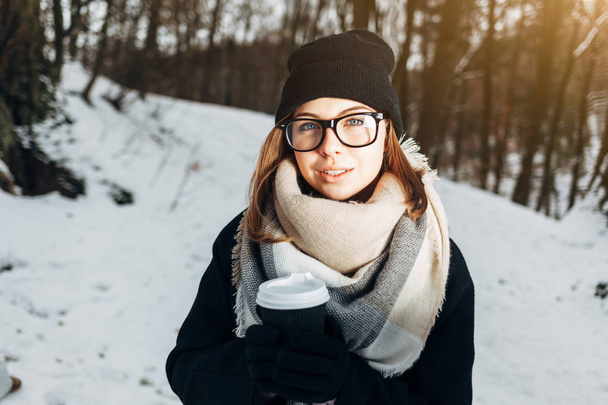 Menina no parque de inverno com xícara de café
 - Foto, Imagem