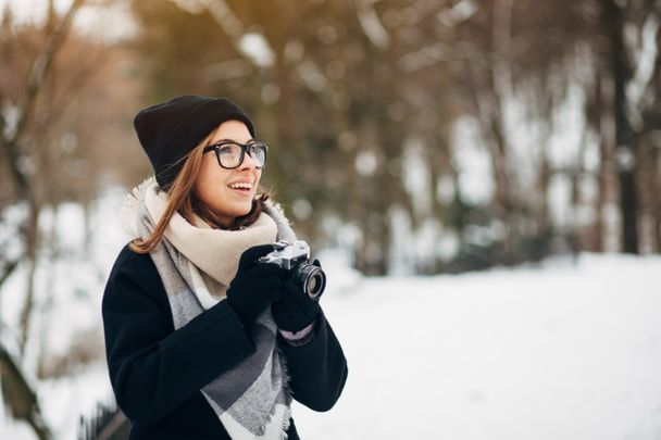 Chica en el parque de invierno con cámara de cine
 - Foto, imagen