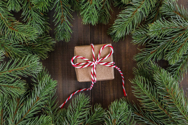 Christmas fir tree branches and brown gift box  on dark rustic w - Foto, Bild
