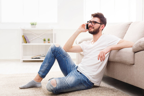 Smiling man in glasses at home with mobile - Photo, Image