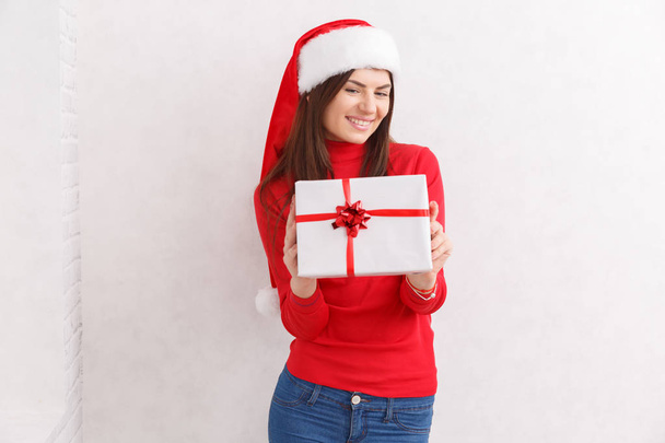 A girl is standing with a gift wrapped against a white background - Foto, immagini