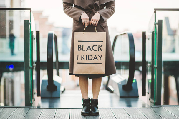 Woman holding Black Friday paper bag - Foto, imagen