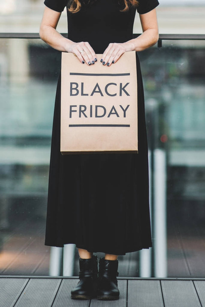 Woman holding Black Friday paper bag - Foto, Bild