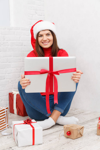 A girl is standing with a gifts wrapped against a white background - Foto, Imagen