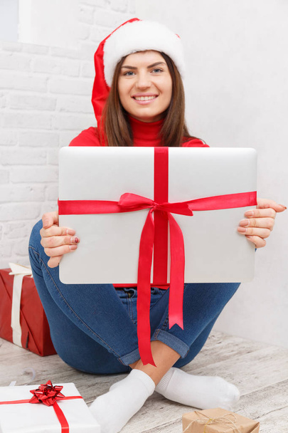 A girl is standing with a gifts wrapped against a white background - Фото, изображение