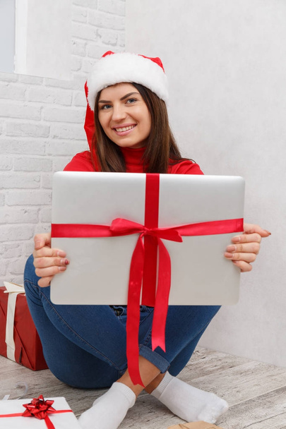 A girl is standing with a gifts wrapped against a white background - Foto, Bild