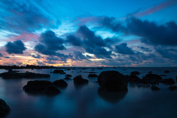 Sonnenuntergang bei Koh Lanta mit Steinen im Meer und Phi Phi Inseln am Horizont, Koh Lanta, Thailand, Asien - Foto, Bild
