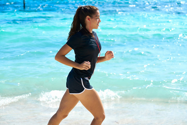 Latin girl running in caribbean shore beach - Фото, зображення