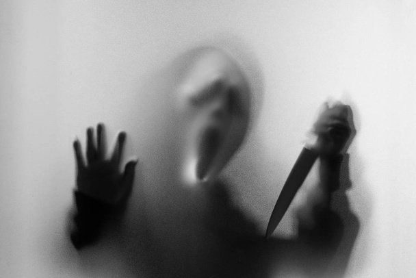 Shadow blur of horror man in screaming mask and show knife in hi - Photo, Image