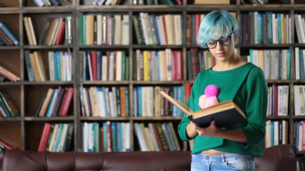 Smart aussehende Studentin liest in Bibliothek - Filmmaterial, Video