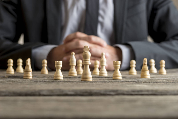 Man wearing suit sitting in front of white chess - Photo, Image