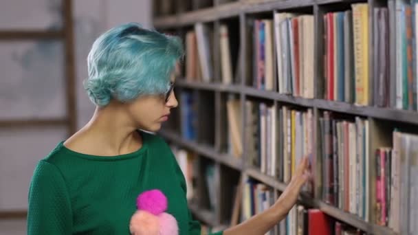 Hipster menina à procura de livro em uma livraria
 - Filmagem, Vídeo