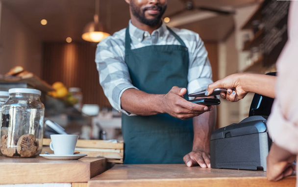 Customer using technology to pay in cafe - Zdjęcie, obraz