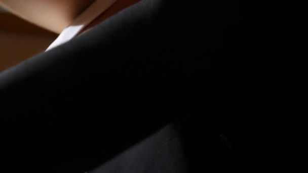 μια γυναίκα με ένα όμορφο στήθος τοποθετεί σε ένα μαύρο σακάκι. 4k, αργή κίνηση - Πλάνα, βίντεο