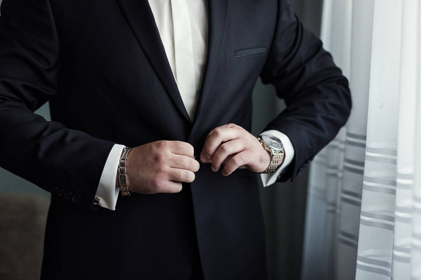 Επιχειρηματίας φοράει ένα σακάκι. Πολιτικός, ανδρικό στυλ, αρσενικό χέρια closeup, αμερικανικές, ευρωπαϊκές επιχειρηματίας, επιχειρήσεις, μόδα και ενδυμασία έννοια - Φωτογραφία, εικόνα