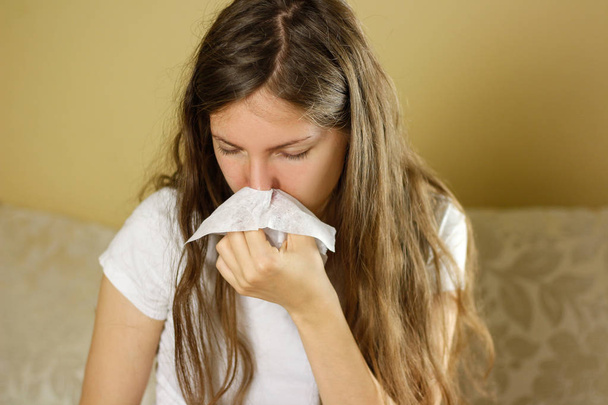 Una chica sonándole la nariz en un pañuelo blanco. Goteo nasal. Clo.
 - Foto, Imagen