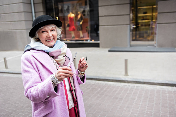 Happy mature woman walking in city with enjoyment - Фото, зображення