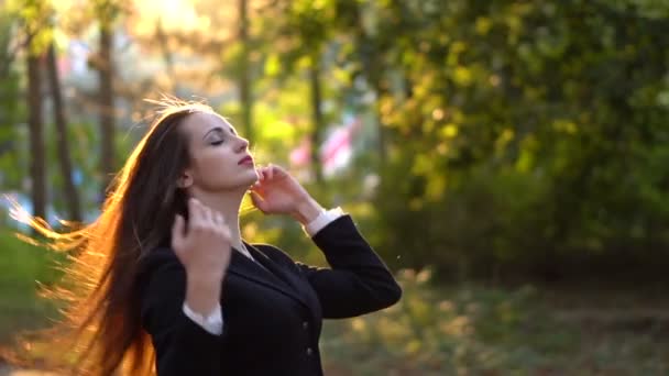Gyönyörű fiatal barna lány ül a szemét a sárga levelek - Felvétel, videó