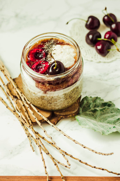 Chia pudding in a jar with fresh cherries and whipped coconut cr - Фото, зображення