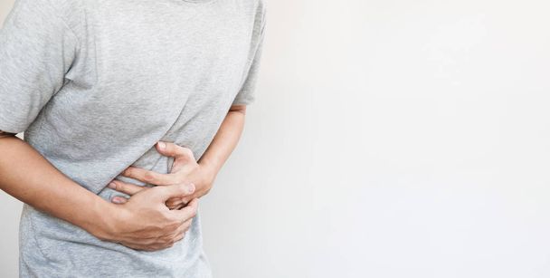 a man touching his stomach, stomach pain and others stomach disease concept, on white background with copy space - Foto, Bild