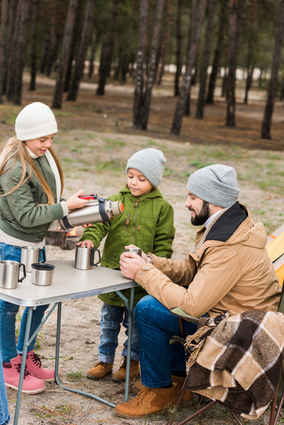 padre e hijos con bebidas calientes al aire libre
 - Foto, Imagen