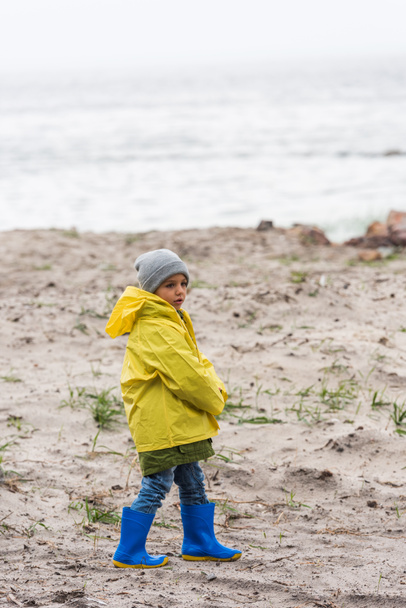 boy in yellow raincoat - Фото, изображение