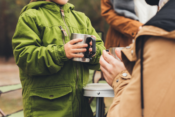 father and son with hot drinks outdoors - Foto, imagen