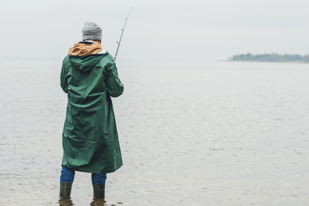 man fishing on rainy day - 写真・画像