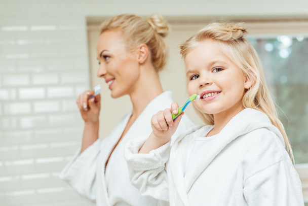 mother and daughter brushing teeth - Photo, Image