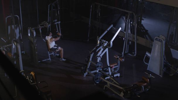 Sportsman athlete bodybuilder trains in the gym. Handsome muscular sports man in fitness club, top view. Fighter - Foto, Bild
